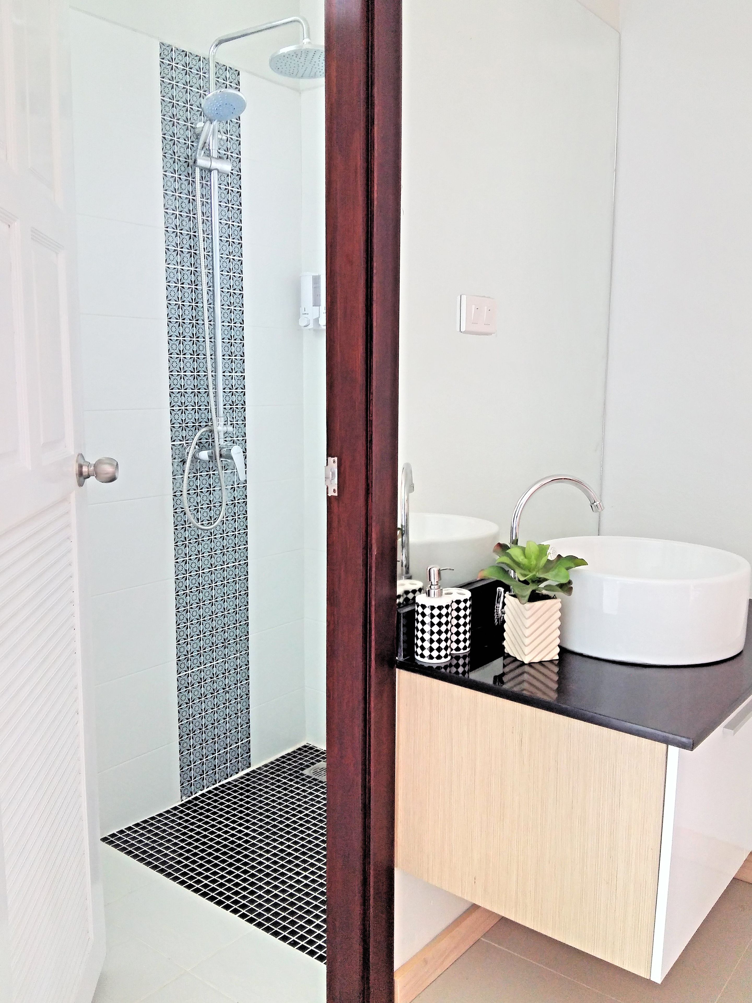 A modern bathroom with a shower, toilet, and sink.
