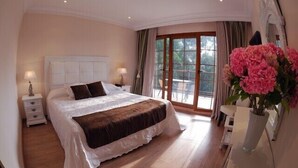 A bedroom with a large bed, a nightstand, a dresser, and a window with curtains.