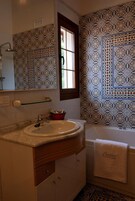 Un baño con lavamanos, espejo y bañera.