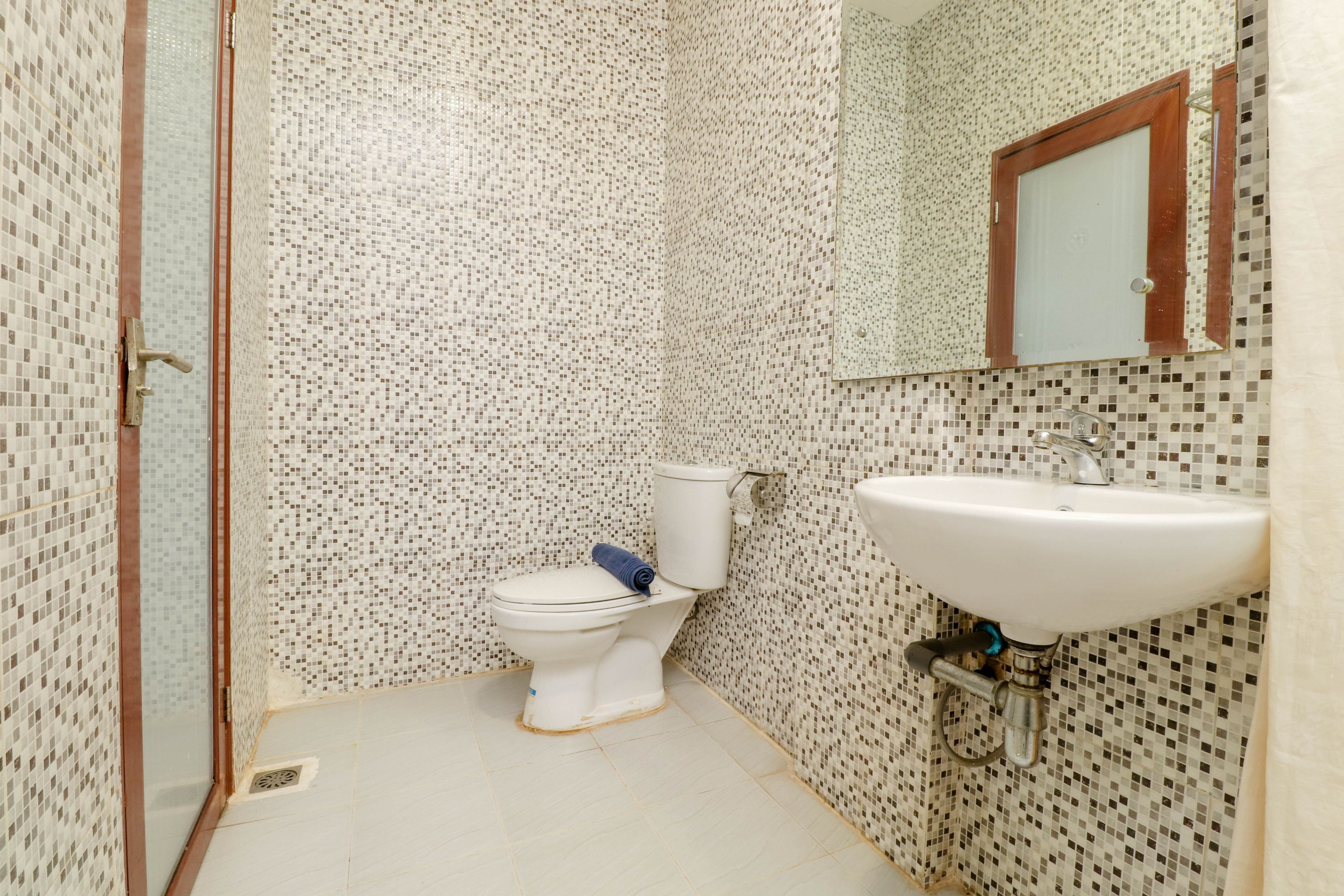 Un baño con inodoro, lavamanos y espejo.