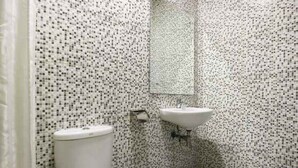 Un baño con inodoro, lavabo y espejo.