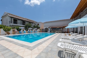 Utomhuspool, parasoller och solstolar