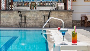 Zona de piscina con bar y sillones de descanso.