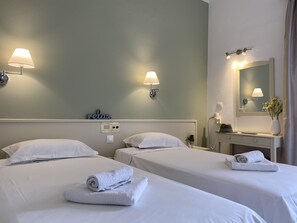 A hotel room with two beds, each with a rolled towel, a wall-mounted lamp, and a sign that says "relax". - La Calma Hotel (Corfu)