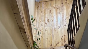 A staircase with a wooden handrail and a potted plant. - Sari Buana Bed & Breakfast (Kuta)