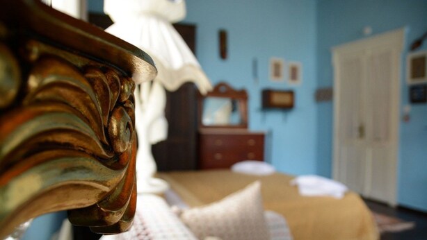 Un dormitorio con una cama, un aparador y un espejo.