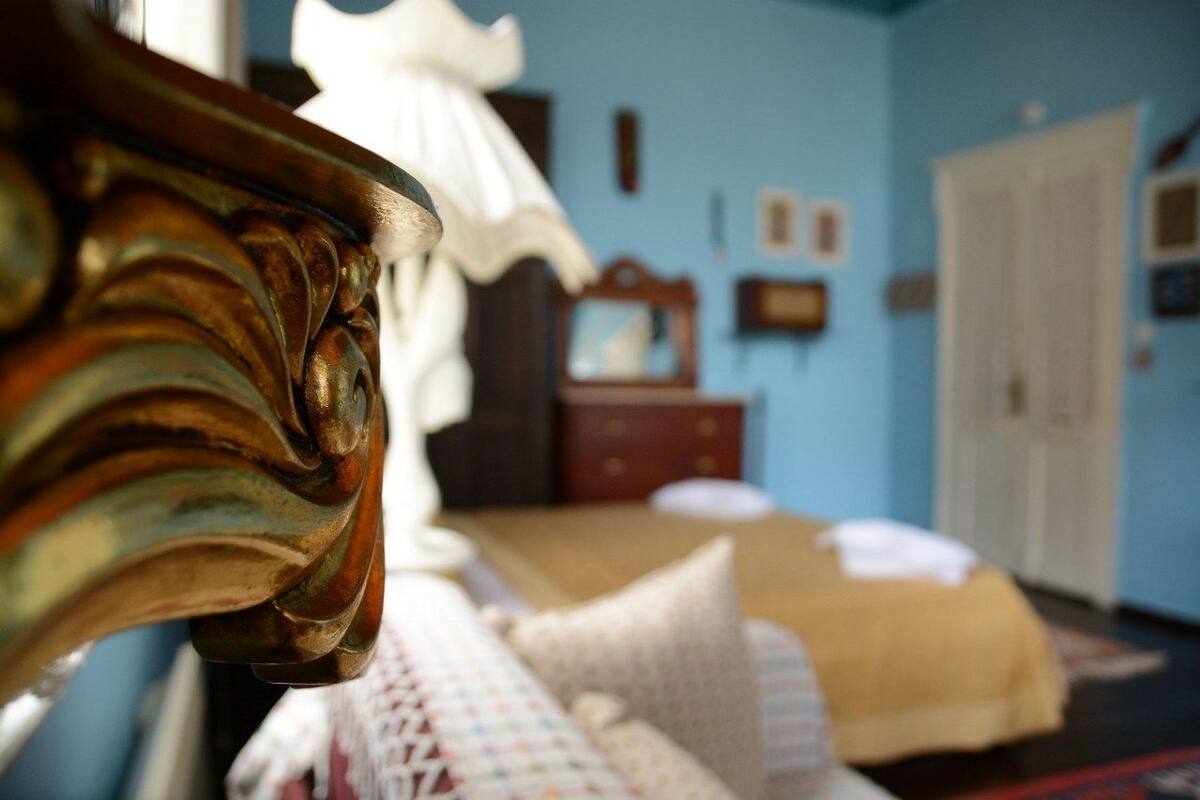 Een slaapkamer met een bed, een dressoir en een spiegel.