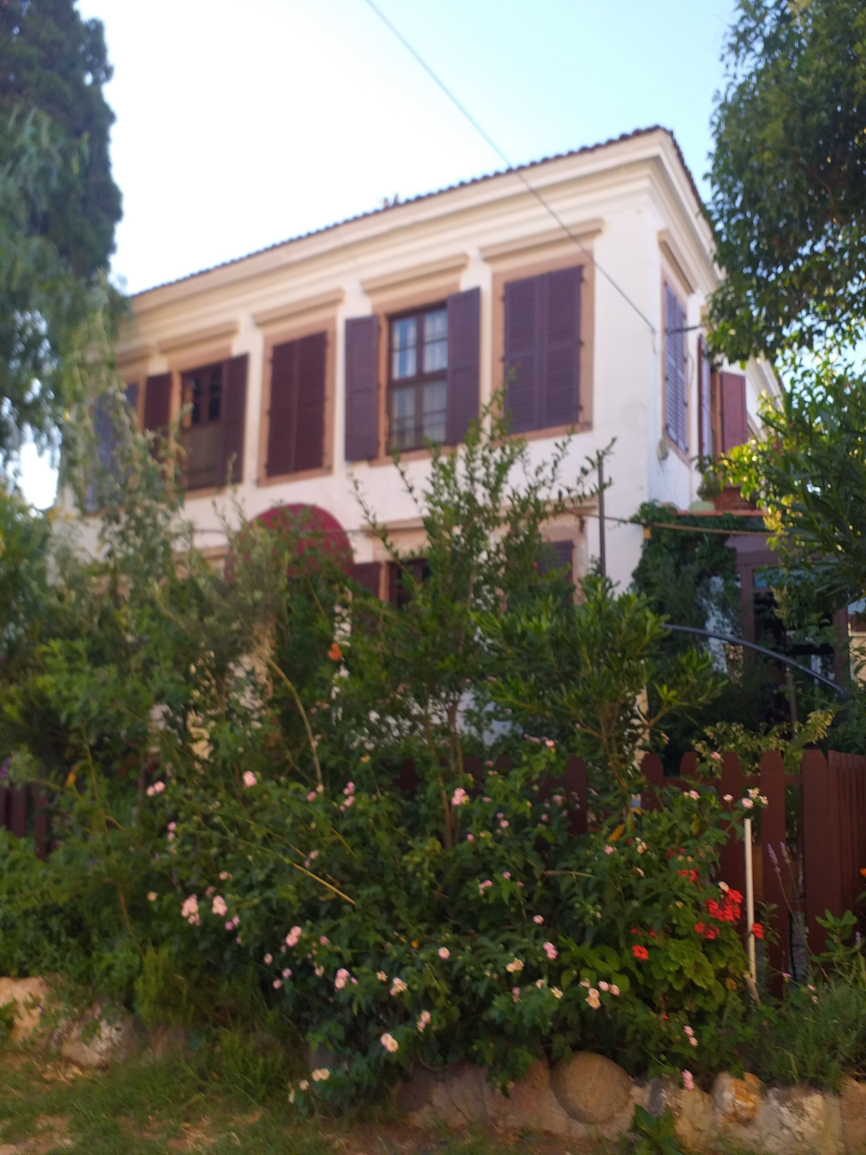 A two-story building with a white facade and dark shutters.