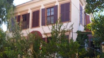 A two-story building with a white facade and dark shutters.
