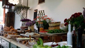 Una mesa de buffet con diversas opciones de comida y un jarrón decorativo.
