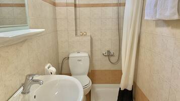 Une salle de bain équipée d’un lavabo, de toilettes, d’une douche et d’une baignoire.