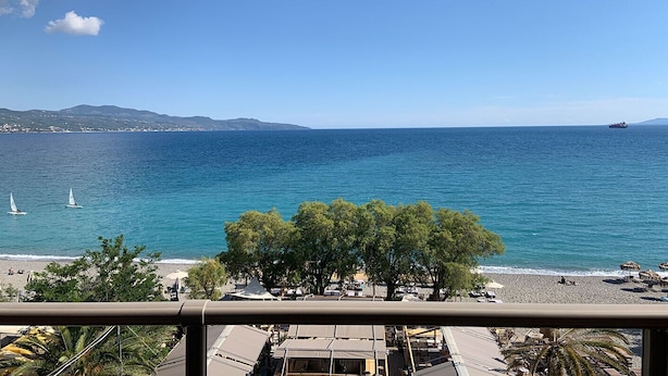 A beach with a view of the sea, a few sailboats, and a distant ship. - Hotel Flisvos (Kalamata)