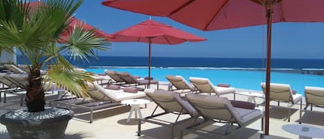 Piscine extérieure, parasols de plage, chaises longues