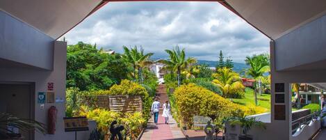 An entrance with a view of a garden and a building in the distance.