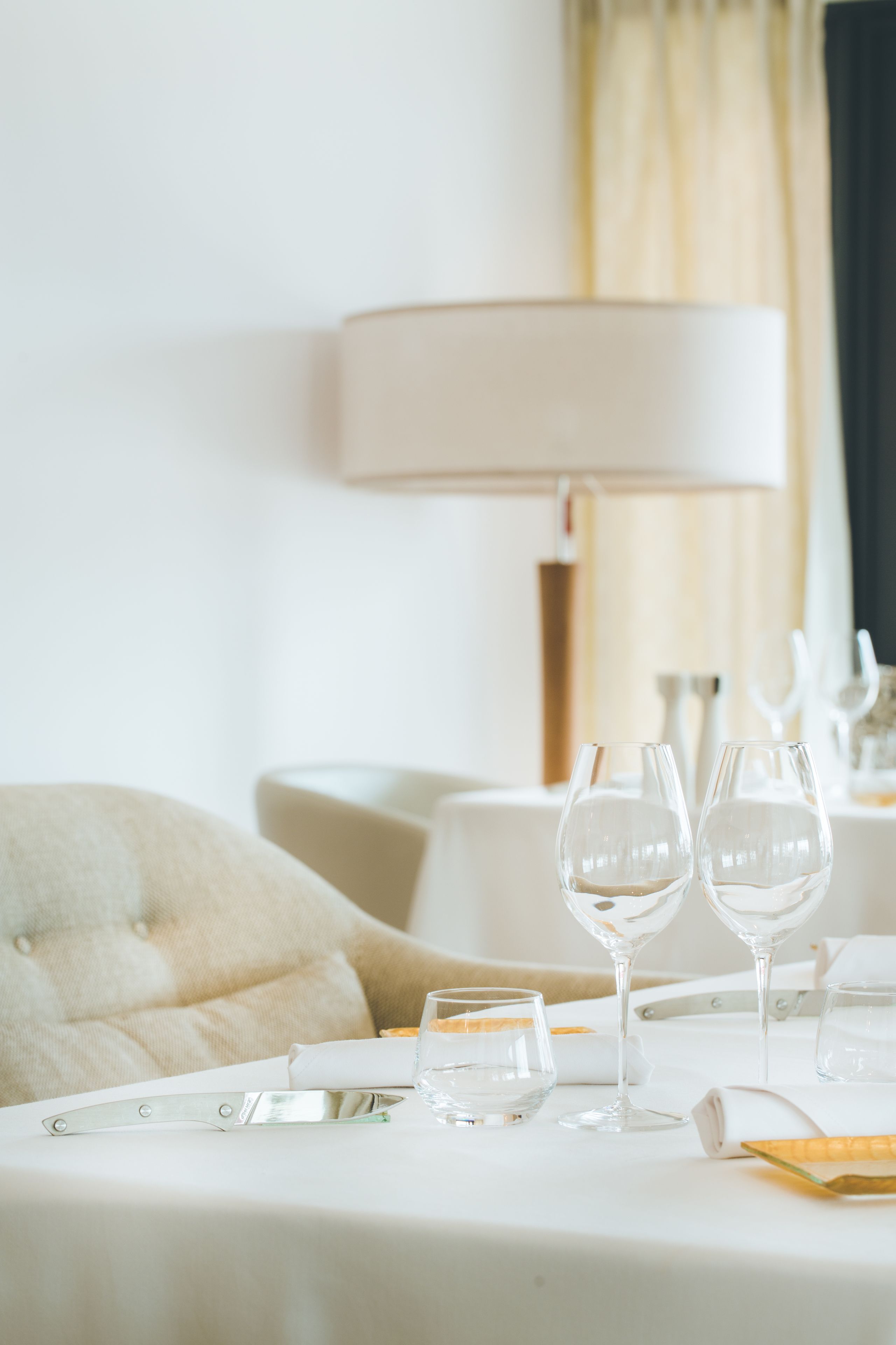 Une table à manger élégamment dressée, avec un couteau, deux verres à vin et un verre à eau.