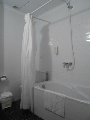 A bathroom with a bathtub, toilet, and shower.