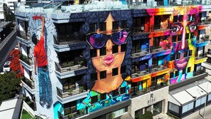 A hotel with a large mural featuring a face with sunglasses.