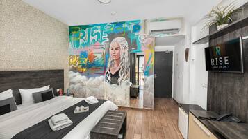 A modern hotel room with a large bed, a desk, and a bathroom.