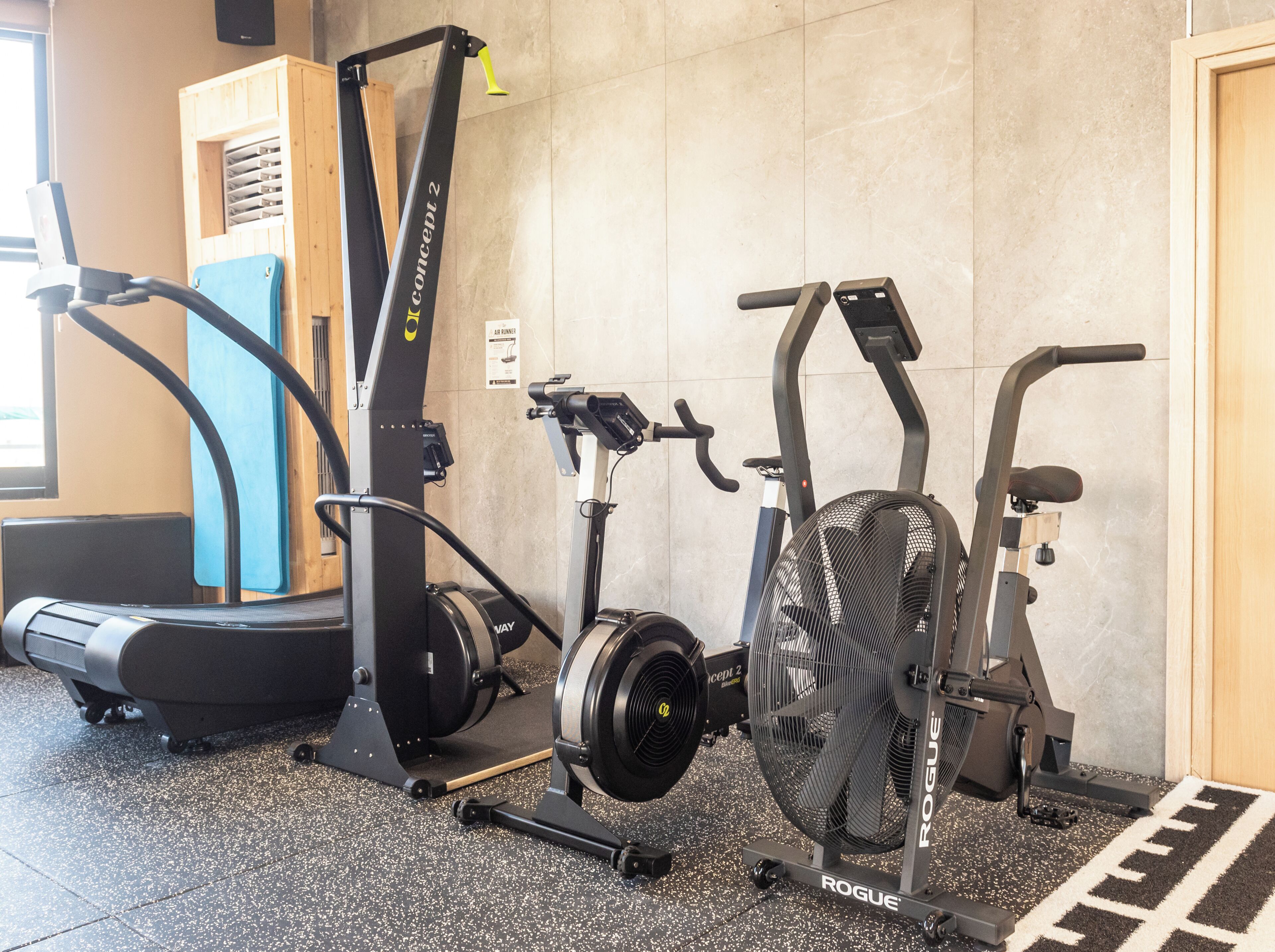 A gym with various exercise equipment including treadmills, an elliptical, and a stationary bike.