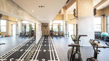 A gym with exercise equipment, a running track, and a wall with a logo.