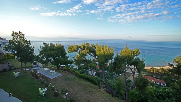 A coastal property with a patio area, outdoor seating, and a view of the sea. - Apollo Apartments & Studios (Kassandra)