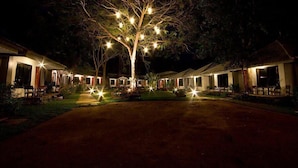 Een boom met lichtjes bij een resort in de nacht.