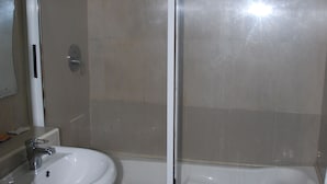 Ein Badezimmer mit einem weißen Waschbecken, einem Spiegel und einer Duschkabine.