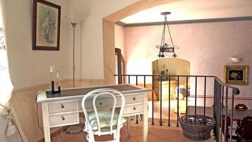 A dining area with a table and chairs, a chandelier, and a staircase.