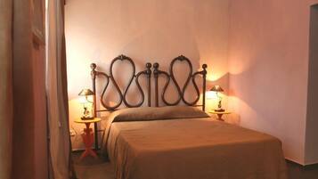 Une chambre à coucher avec un lit, deux tables de chevet avec des lampes et un rideau sur le côté gauche.