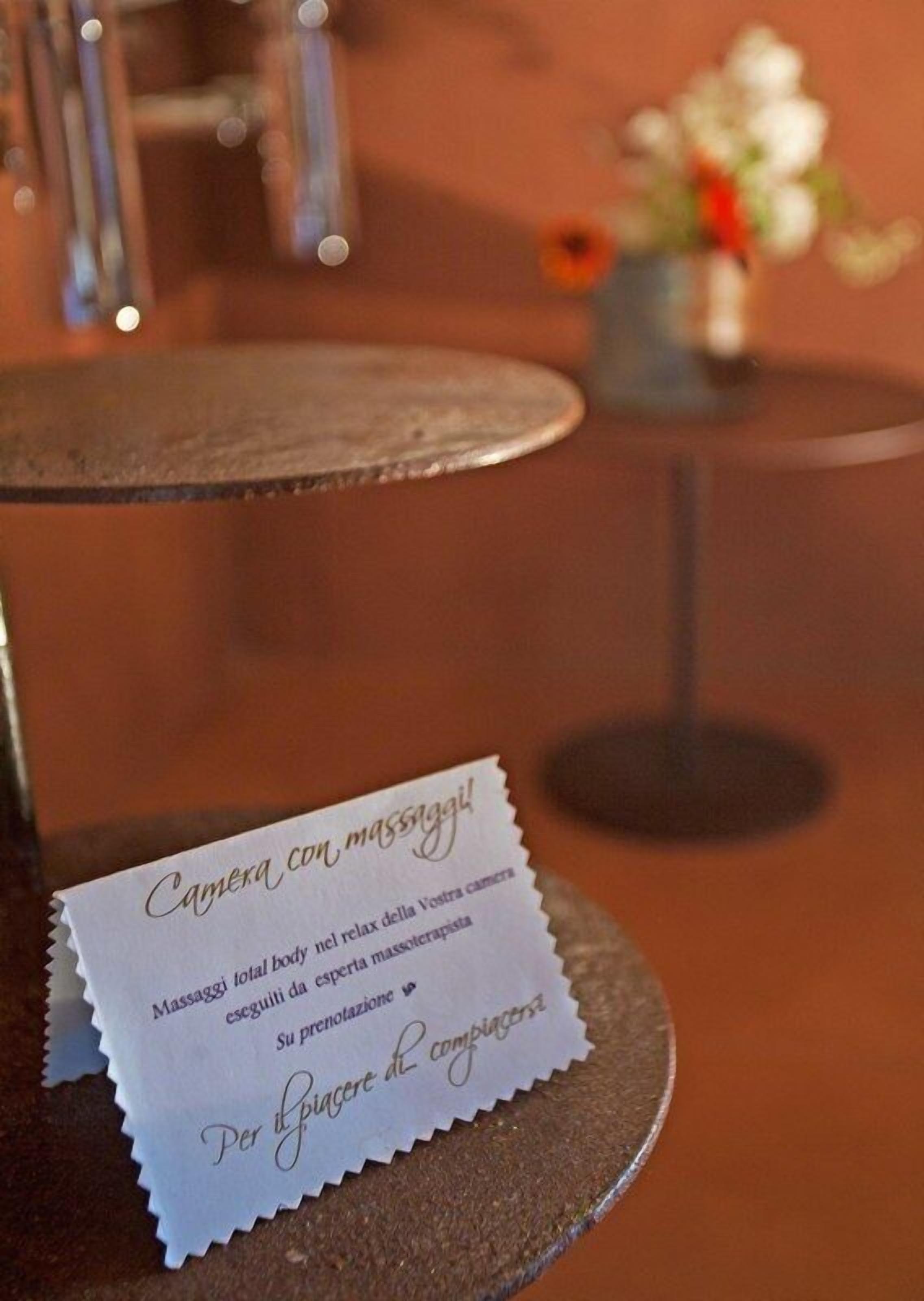 A table with a sign that reads "Camera con massaggi" indicating massage services.