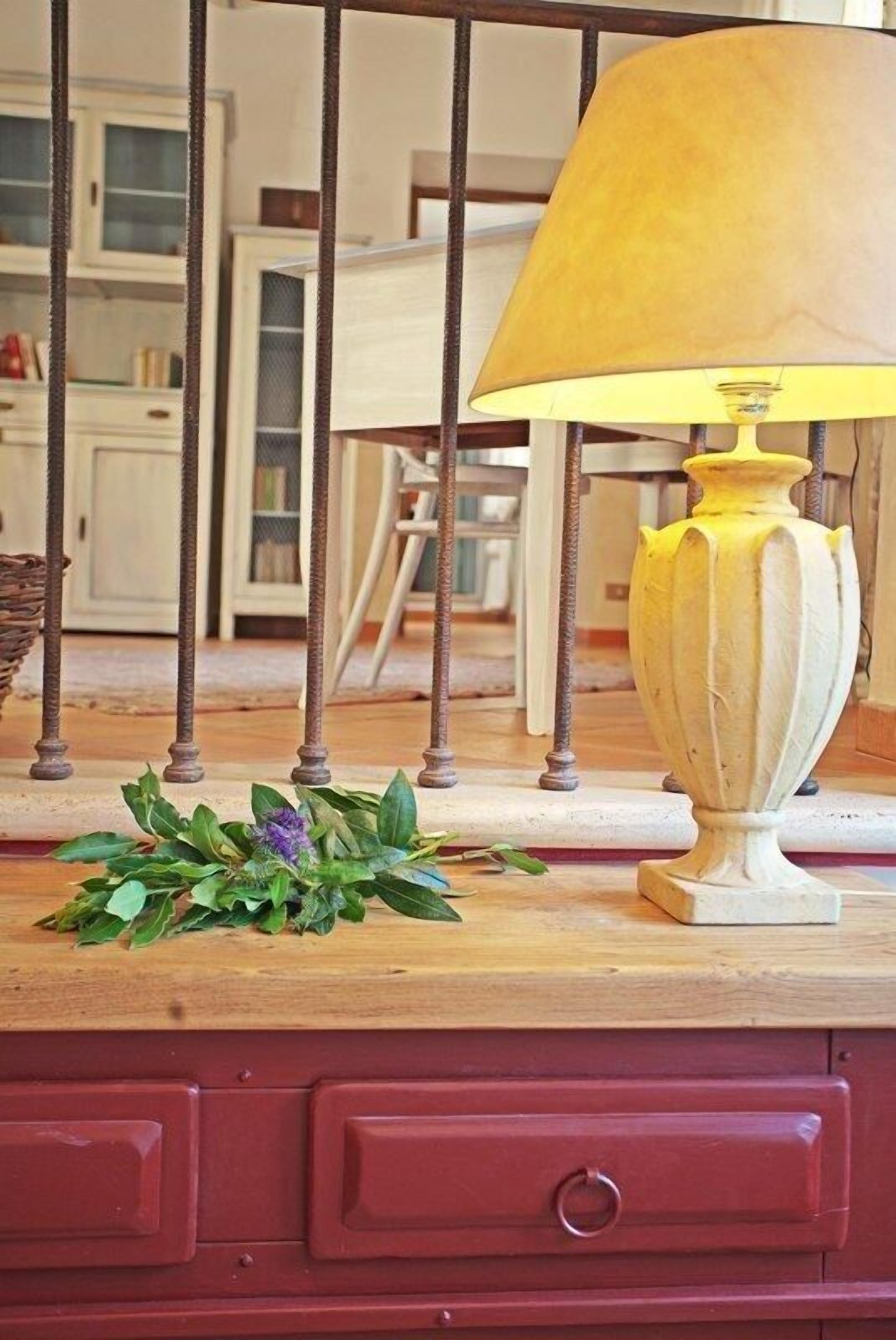 A lamp with a yellow shade on a wooden surface.