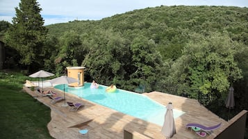 Una piscina al aire libre, sombrillas, tumbonas