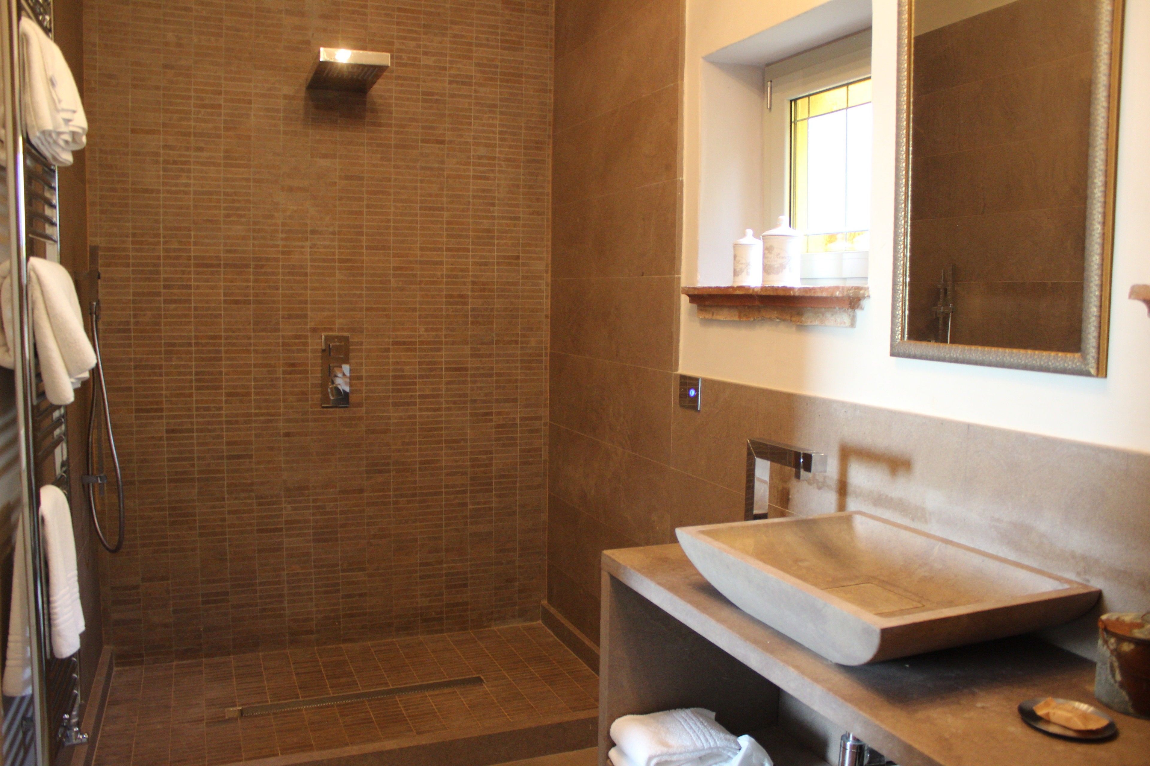 Ein Badezimmer mit Dusche, Waschbecken und Spiegel.