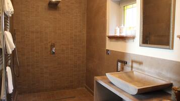 Ein Badezimmer mit Dusche, Waschbecken und Spiegel.