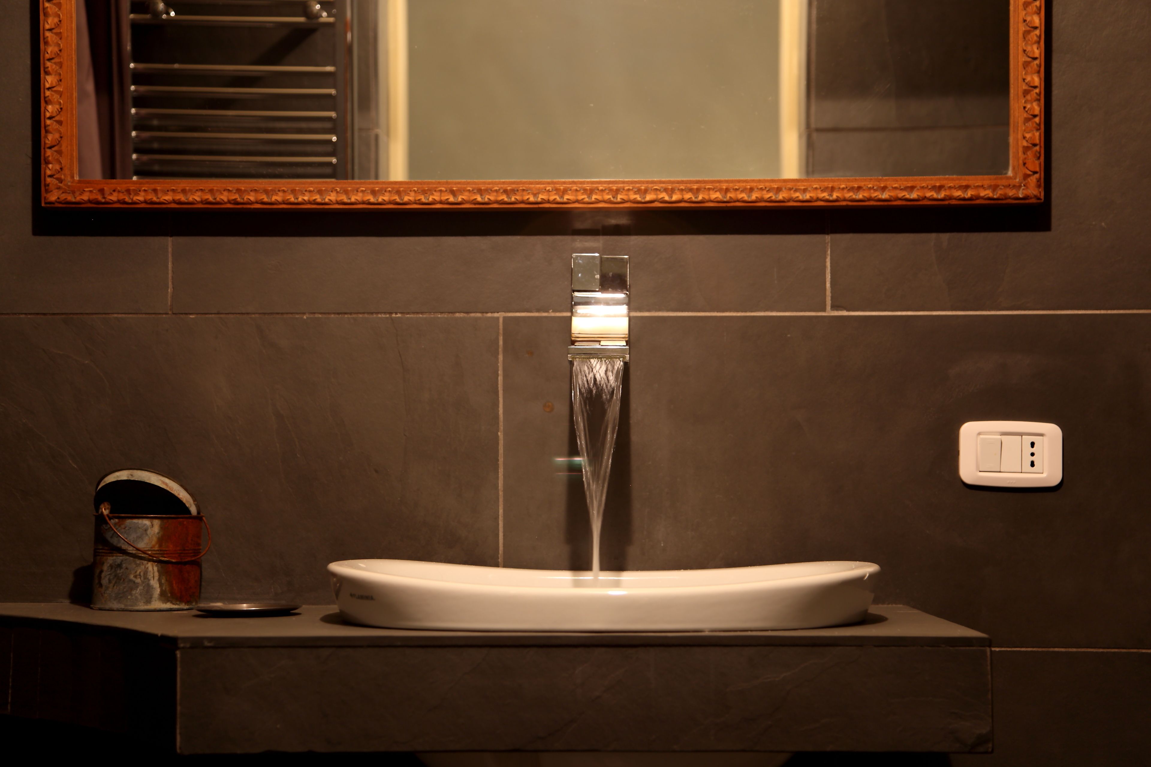 Une salle de bain avec un lavabo moderne, un miroir et un porte-serviettes.