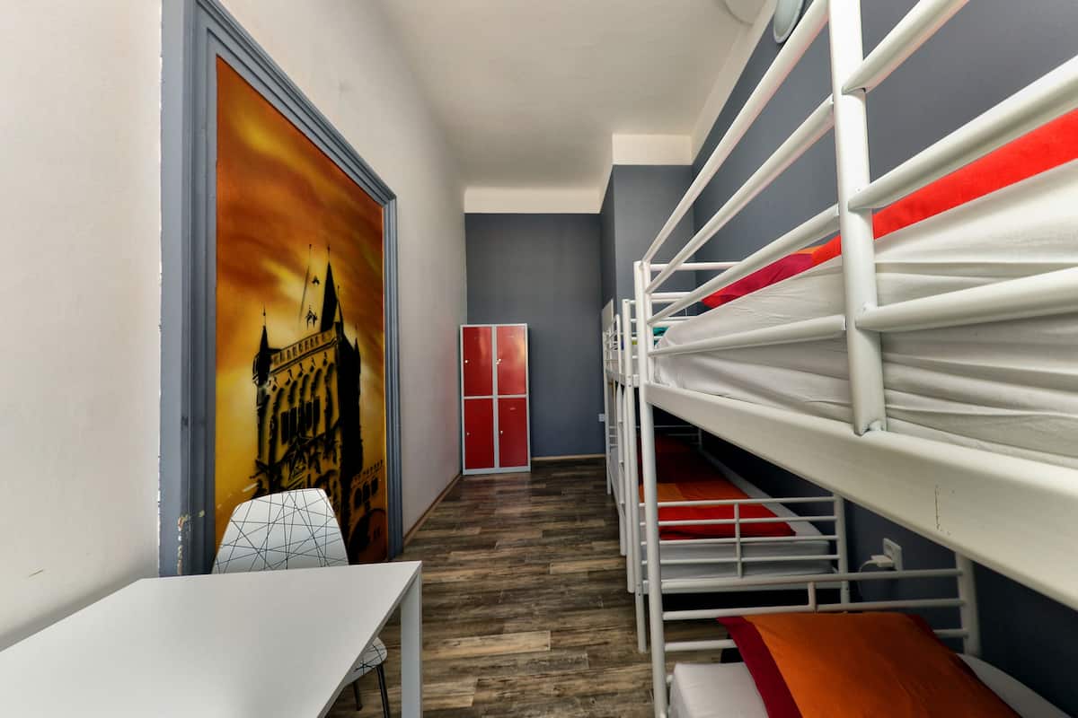 A room with bunk beds, a desk, and a chair.