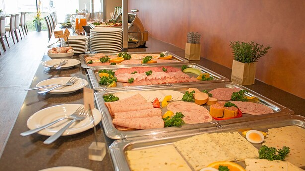 A buffet with various food items and utensils. - Qualitel Hotel Hilpoltstein (Hilpoltstein)