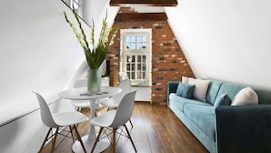 Een moderne loft met een eethoek, een zithoek en een metselwerk muur.