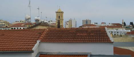 A cityscape with a prominent tower and multiple buildings with red-tiled roofs.