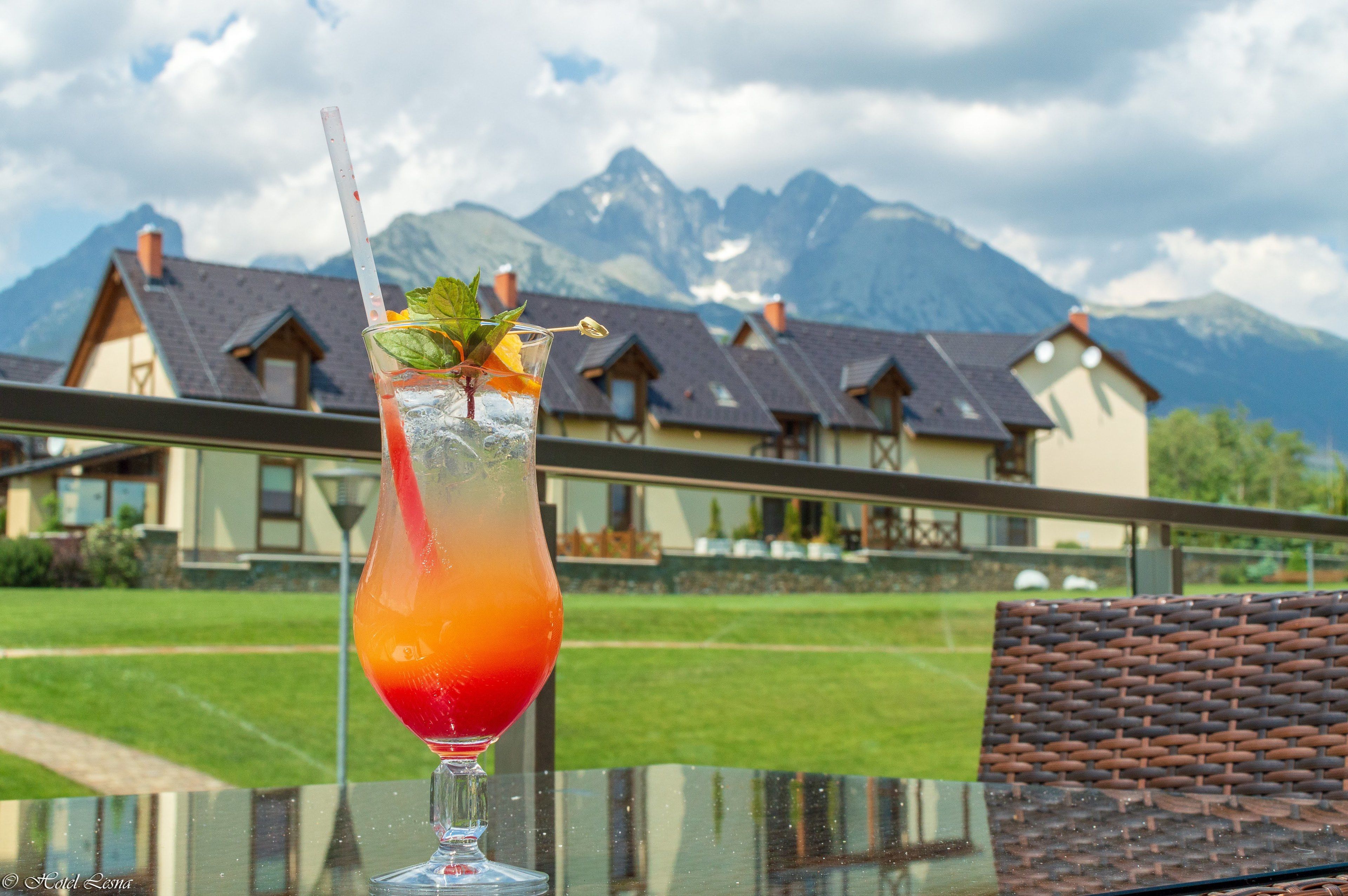 A cocktail on a table with a mountain view in the background.