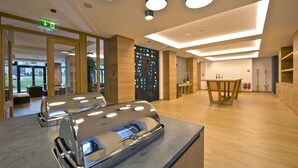 Un vestíbulo moderno de hotel con un mostrador de recepción, piso de madera y una pared con pantalla digital.