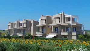 A modern multi-story residential building with balconies and air conditioning units. - Niovi Apartments (Kassandra)