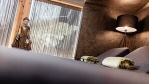 A room with a bed, a lamp, and a statue. - Romantic & Family Hotel Gardenia (Selva di Val Gardena)