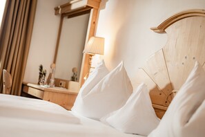 Una cama bien hecha con almohadas blancas y un cabecero de madera.