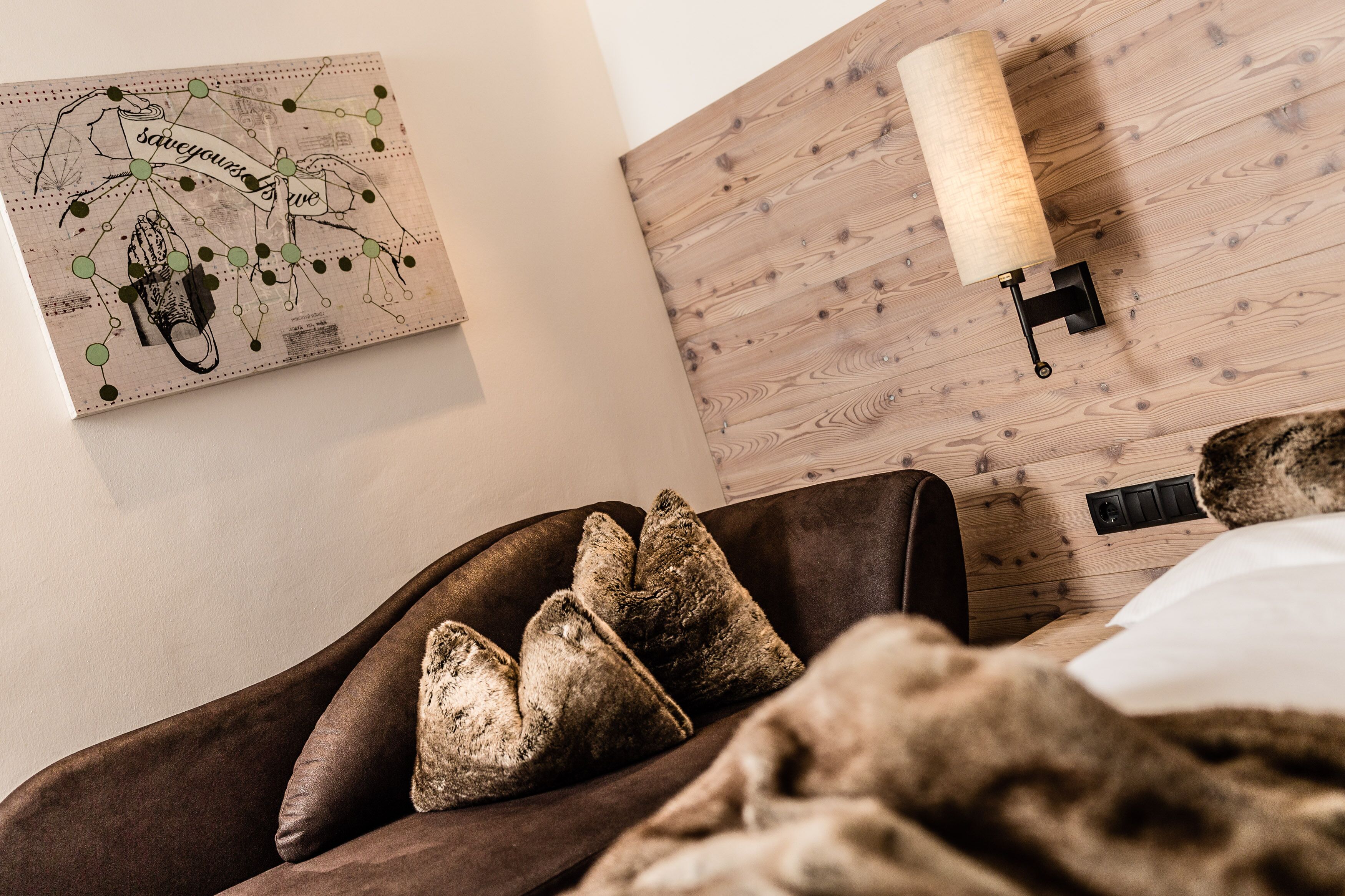 Une chambre confortable avec une tête de lit en bois, une décoration murale représentant une carte et un lit avec une couverture et des oreillers.