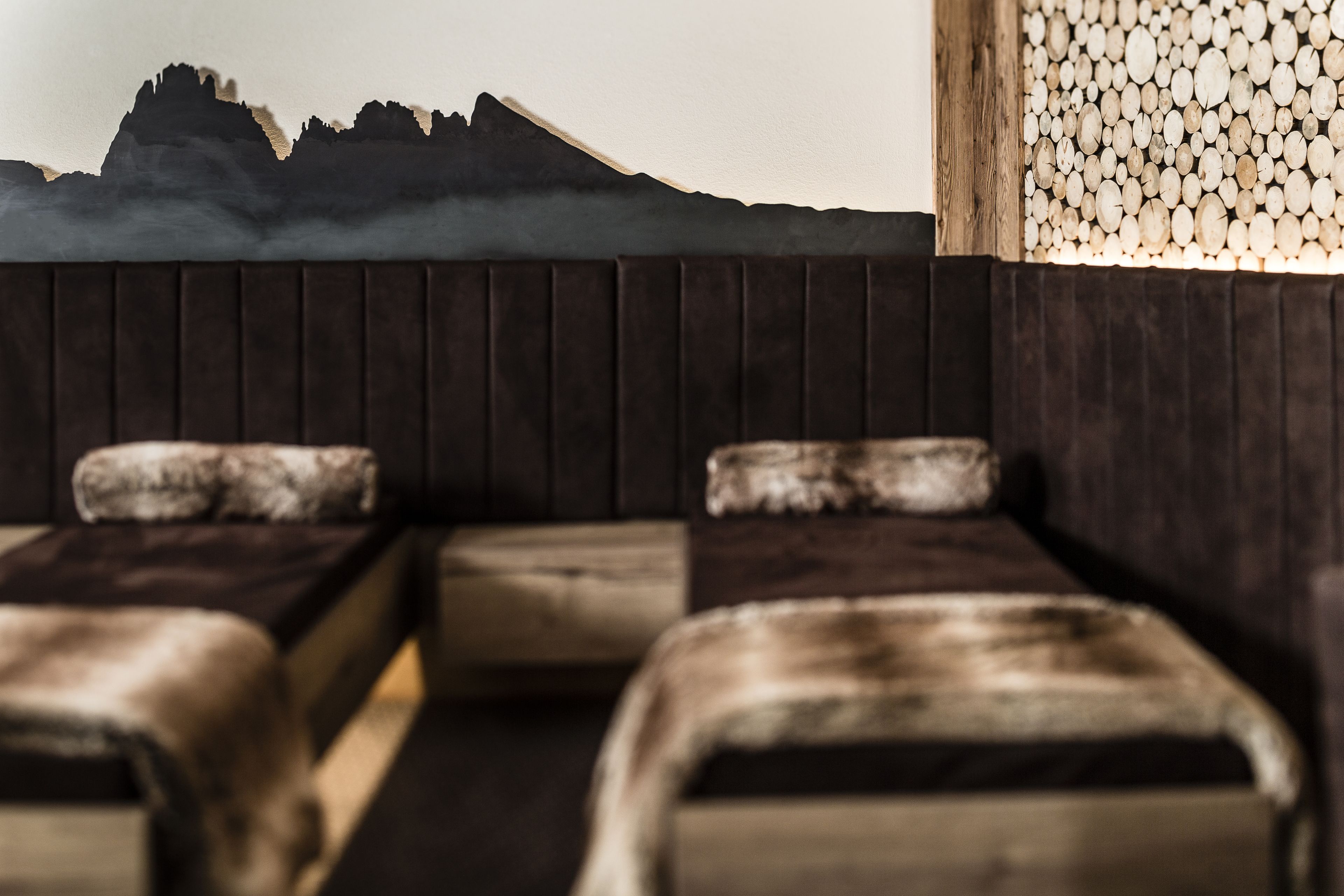 A room with a wooden bench and a wall with a mountain silhouette.