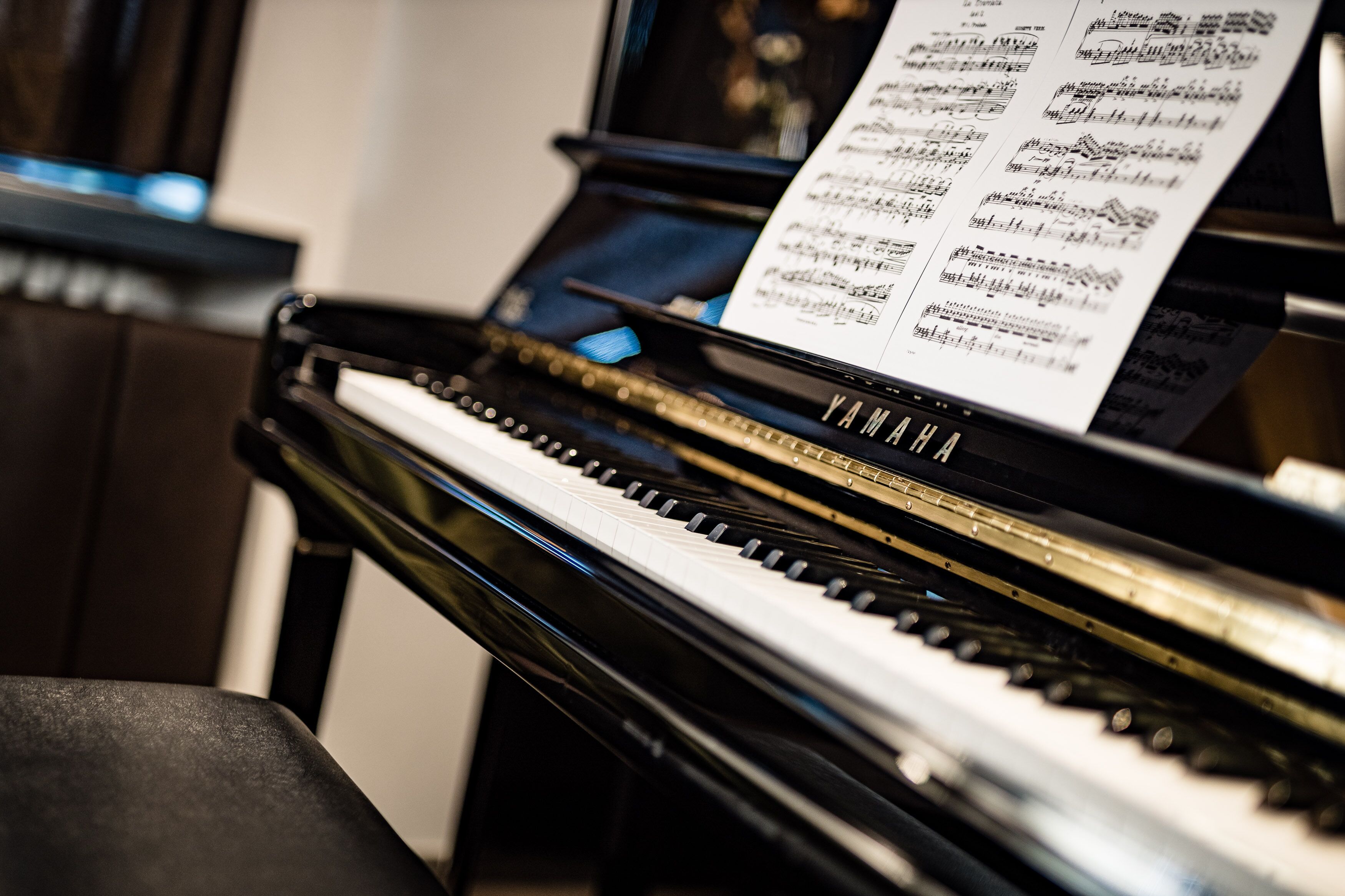 A grand piano with sheet music on its stand.