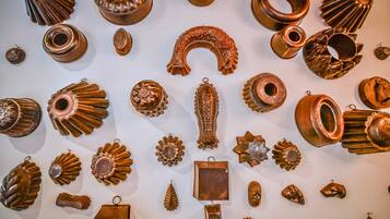 Una composizione di diversi oggetti metallici, tra cui elementi decorativi e forse gioielli, esposta su una parete.
