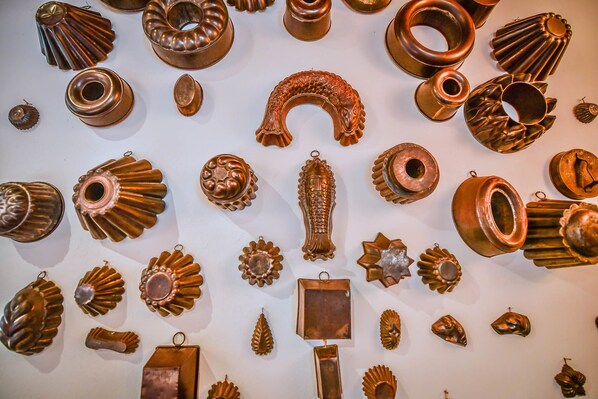A collection of various metal objects, including decorative items and possibly jewelry, displayed on a wall. - Relais Oroscopo (Sansepolcro)