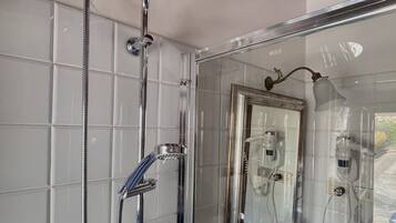 Un baño moderno con ducha de vidrio, un espejo grande y una bañera.